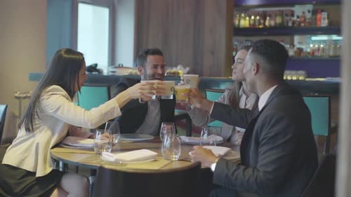 Des amis qui tintent des verres au restaurant
