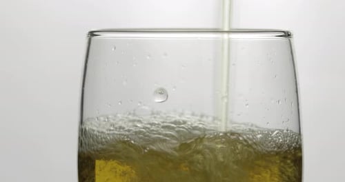 Pouring Cold Golden Light Beer Into a Glass. Craft Beer Making Bubbles and Foam
