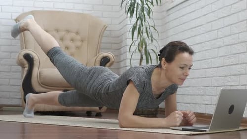 Woman Doing Plank Exercise Watching Laptop