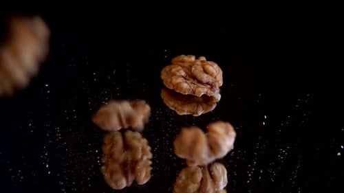 Close Up Walnuts Falling on Black Background