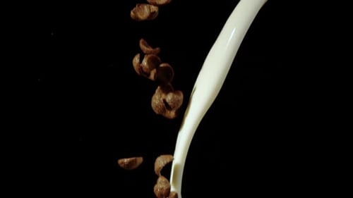 Pouring Milk on Cereal Pieces on Black Background