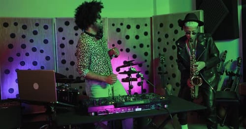 Dj and female saxophone musician playing music inside boutique recording studio