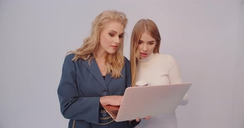 Stylish Women Working on a Laptop Together