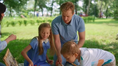 Happy Family Preparing Picnic in Park