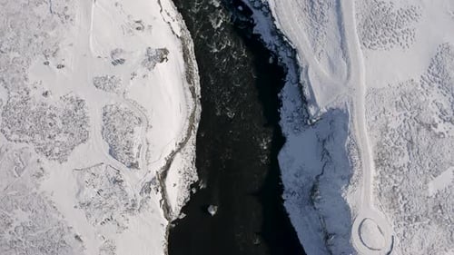 Aerial View of Godafoss Waterfall with Snowy Shore and Ice. Iceland. Winter 2019
