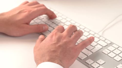 Hands Typing on Computer Keyboard in Office