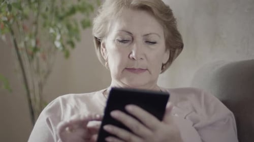 Senior Woman Using Tablet Device Indoors