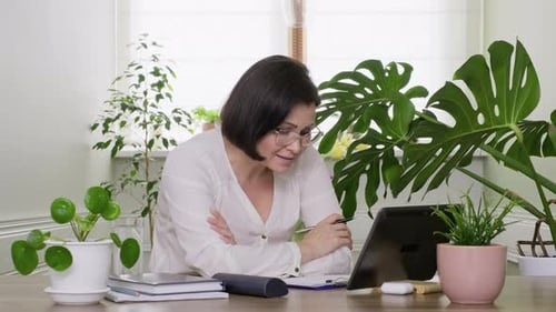 Woman Working At Desk With Tablet and Plants