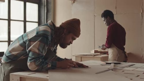 Two Multiethnic Joiners Working in Workshop