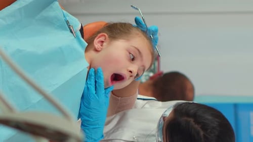 Child at Dentist Examines Teeth
