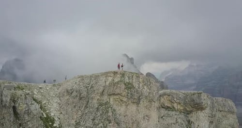 Aerial drone view of a man and woman couple hiking in the mountains.