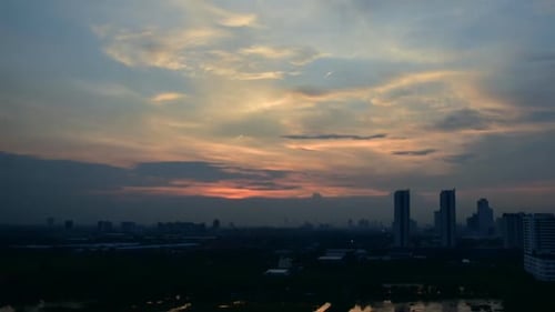 Sunset cloudy sky time lapse on downtown cityscape building in the evening