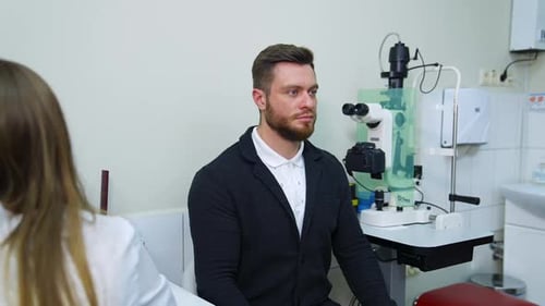 Patient während des Sehtests. Junger männlicher Patient überprüft das Sehvermögen und schließt das Auge