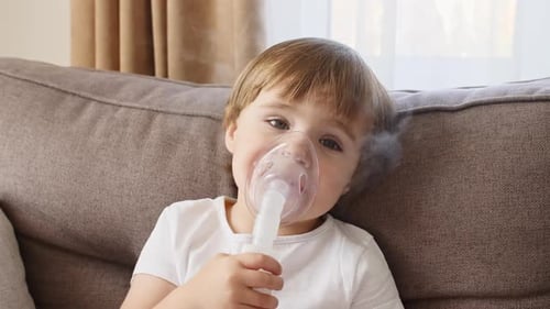 Petite fille tenant un masque, un nébuliseur, inhalant des vapeurs et des médicaments dans les poumons