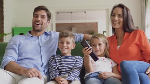 Smiling Family Together on Sofa in Living Room