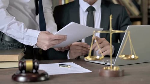 Primer plano de la mano del juez firmando los documentos en la sala del tribunal