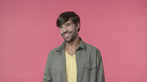 Man Smiles, Nods, and Waves on Pink Background
