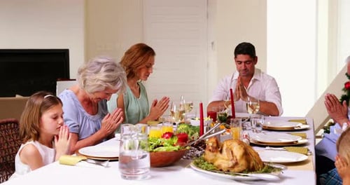 Família extensa pedindo graça antes do jantar de Natal 4k