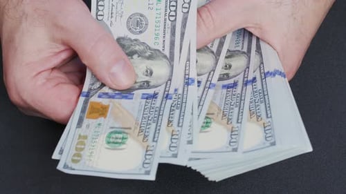 Hands Counting Stacks of New US Hundred Dollar Bills