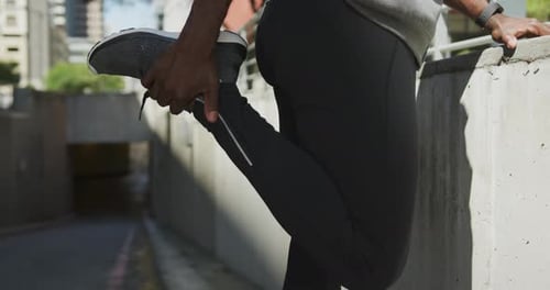 Man Stretching Leg in Urban Environment