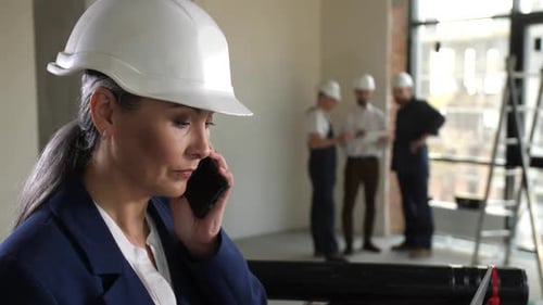 Woman Designer Talking Phone and Working on Laptop