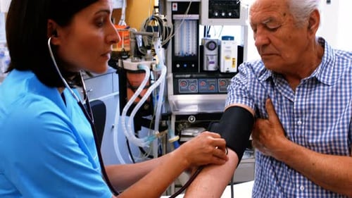 Doctor Checking Senior Man's Blood Pressure in Hospital