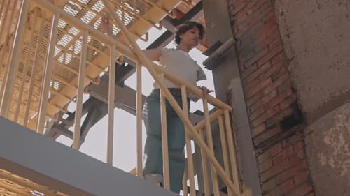 Young Adult Performing Artistic Movement on Fire Escape