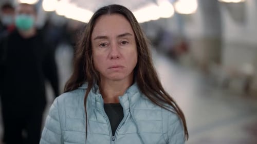 Sad and Tired Townswoman in Pedestrian Subway Looking at Camera