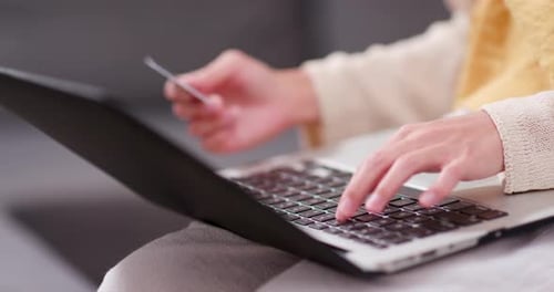 Frau nutzt Laptop-Computer für Online-Einkäufe mit Kreditkarte