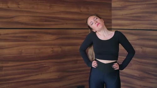 Woman Doing Neck Stretches for Fitness Indoors