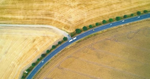 Aerial View Of A Country Road With Cars Moving Between Agricultural Fields