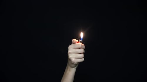 Close Up Of Hand Holding A Burning Lighter