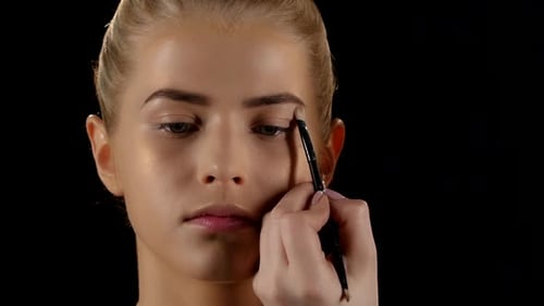 Doing Make-up for a Woman Using Eyebrows Brush. Black. Closeup