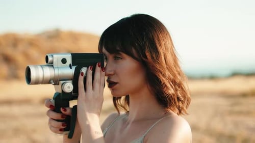 Pretty Girl with Vintage 8Mm Camera in the Countryside