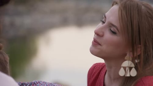 Auburn Haired Woman Talking with Friends by Lake