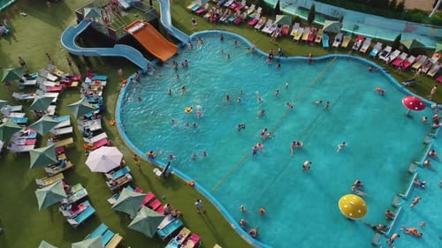 People swim and have fun in the large pool at the water park.