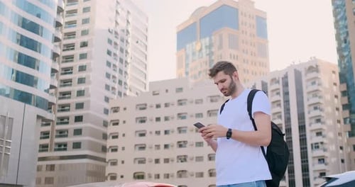 Man Using Phone in Modern City Environment