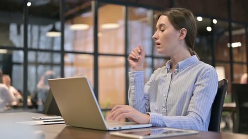 Woman Working on Laptop Coughing in Office