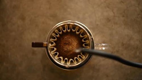 Pouring Water Over Coffee Grounds in Filter
