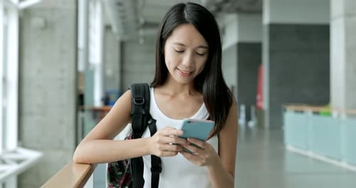 Woman using mobile phone in the university school
