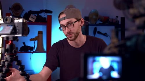 Kaukasischer Blogger im Studio vor Kameras fragt nach Put Like und Abonnieren-Kanal