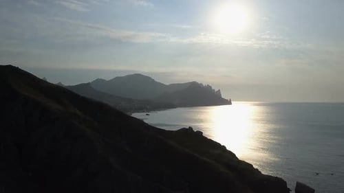 Vuelo sobre el mar y las montañas al amanecer. Vista aérea de la montaña Kara-Dag en Crimea.