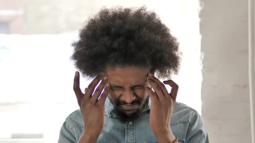 Man with Curly Hair Massaging Temples