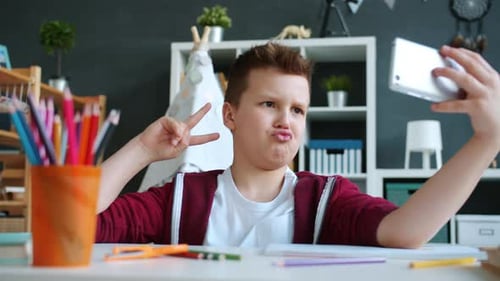 Happy Boy Takes Selfie with Tablet at Desk