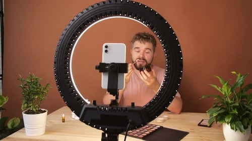 Joven filmando su episodio de videoblog sobre nuevos productos cosméticos mientras
