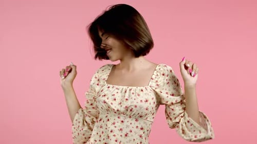 Beautiful Woman Dancing Energetically and Actively on Pink Studio Background. Cute Girl's Portrait