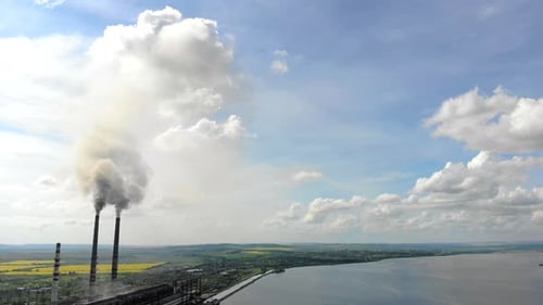 Umweltverschmutzung aus der Luftaufnahme. Zwei hohe Rohre, die schwarzen Rauch in die Atmosphäre
abgeben