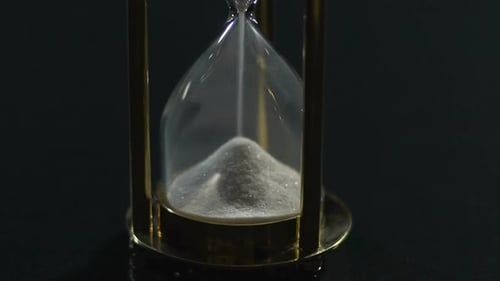 White Sand Flowing in Hourglass Past and Future Transience of Life Close-Up