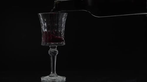 Pouring red wine into crystal glass