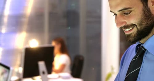 Smiling Man Working on Tablet in Office